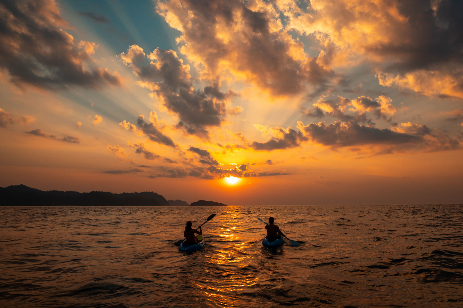 female-male-sailing-with-canoes-close-each-other-sunset